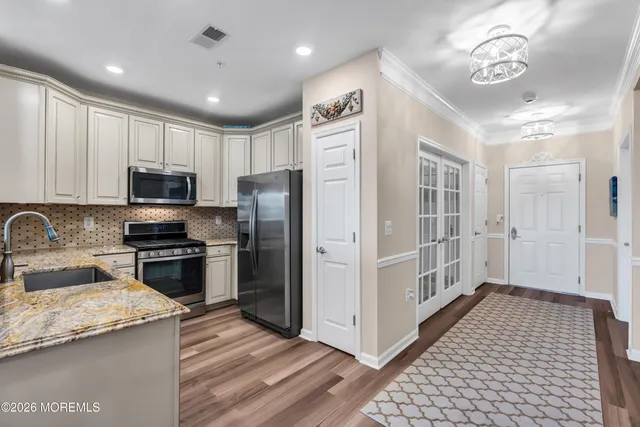 a kitchen with stainless steel appliances granite countertop a refrigerator a stove a sink and a microwave