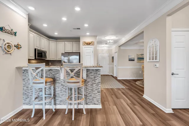 a kitchen with stainless steel appliances kitchen island granite countertop a refrigerator and microwave