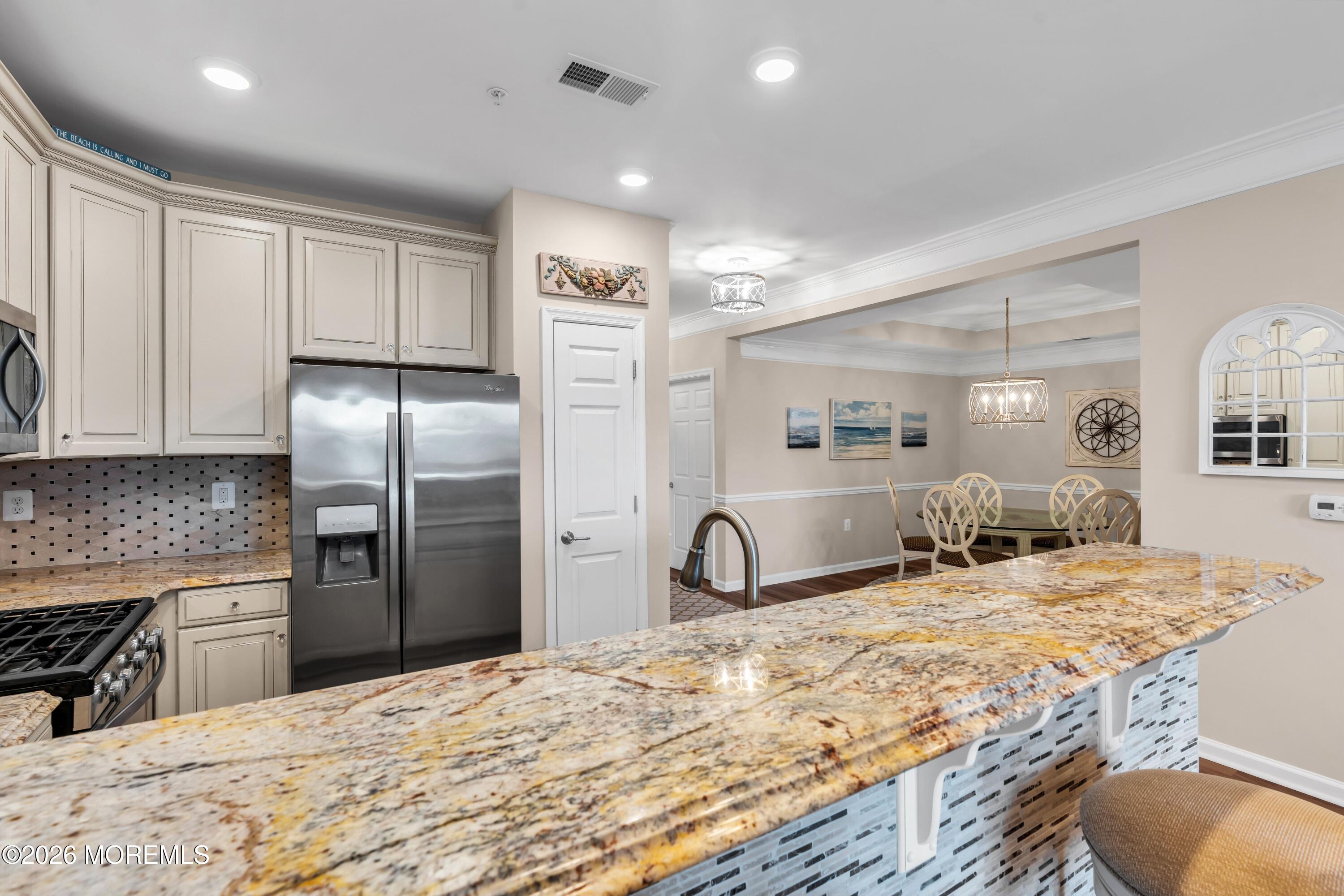 2201 River Road, Unit 4303 Point Pleasant, NJ 08742 - Photo 17 of 36 a large kitchen with kitchen island granite countertop a refrigerator a sink a stove and oven