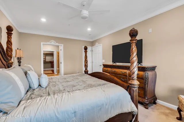 a bedroom with a bed and a flat tv screen on wall