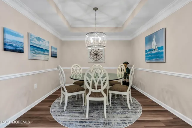 a view of a dining room with furniture wooden floor and chandelier