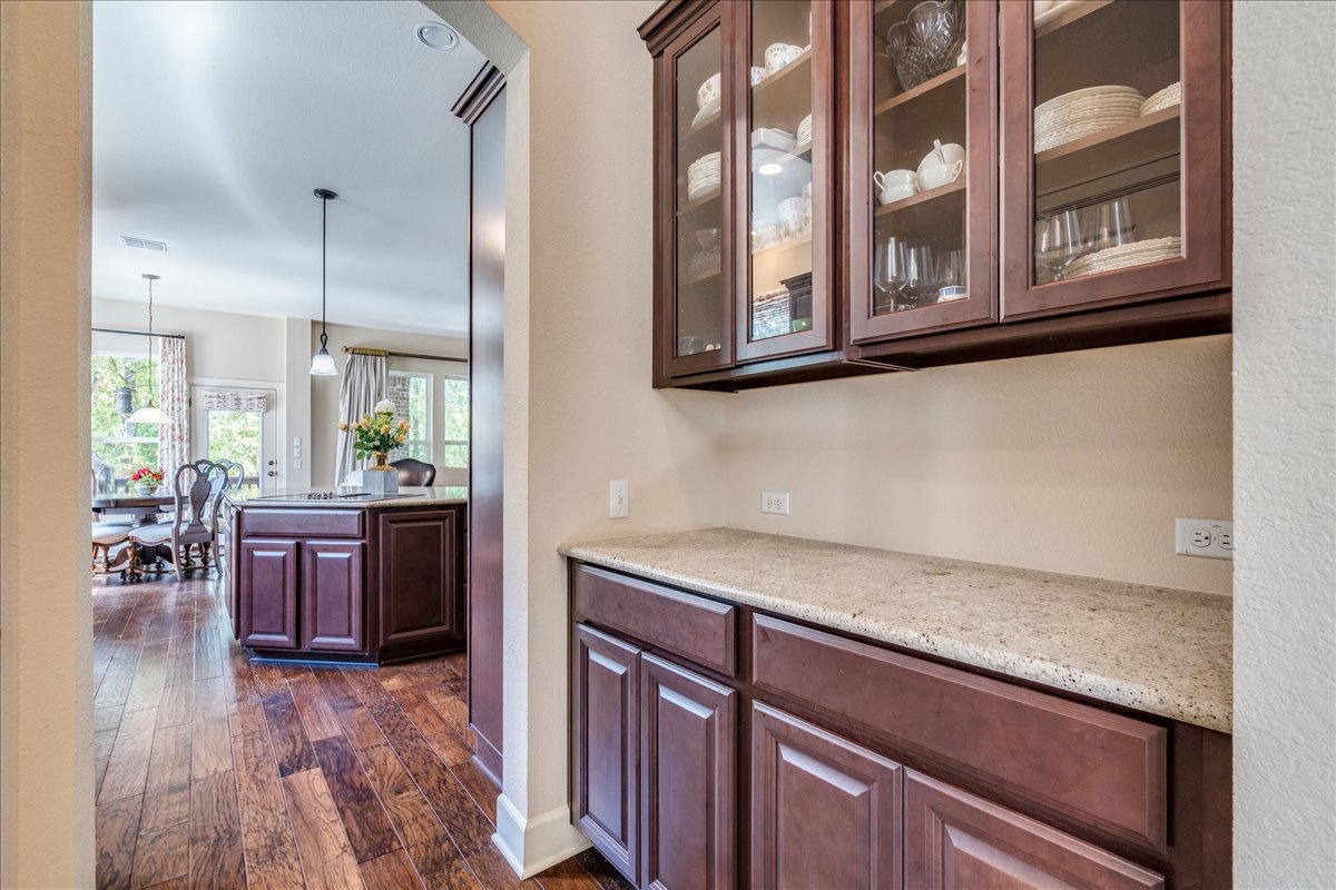 12909 Medina River Way Austin, TX 78732 - Photo 15 of 36 Dark wood cabinetry and granite counters define this convenient butler's pantry area.