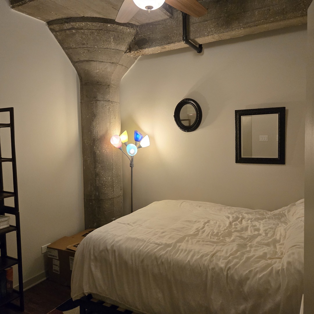 1111 West 15th Street, Unit 228 Chicago, IL 60608 - Photo 20 of 32 a bedroom with a bed and a chandelier