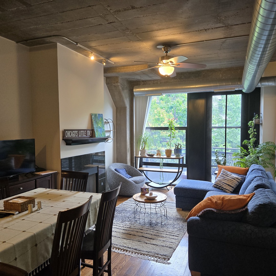 1111 West 15th Street, Unit 228 Chicago, IL 60608 - Photo 7 of 32 a living room with furniture a fireplace and a large window