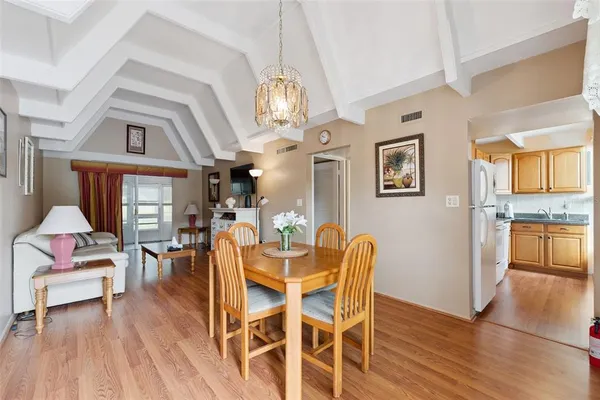 a view of a dining room with furniture a chandelier and wooden floor