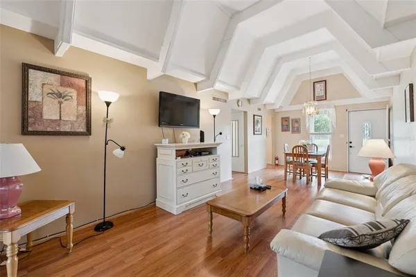 a living room with furniture a flat screen tv and kitchen view