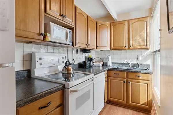 a kitchen with stainless steel appliances granite countertop a sink stove and cabinets
