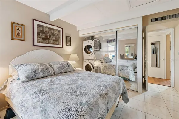 a bedroom with a bed and a large mirror