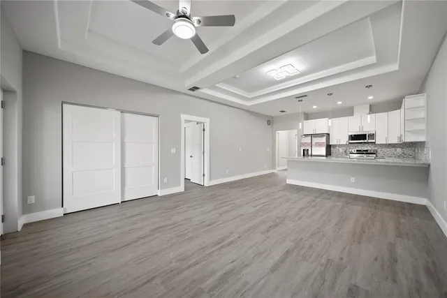 a view of kitchen with refrigerator stove and wooden floor