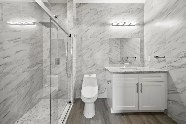 a bathroom with a granite countertop toilet sink and mirror
