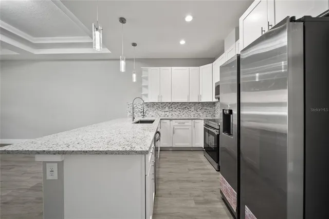 a kitchen with stainless steel appliances granite countertop a refrigerator sink and cabinets