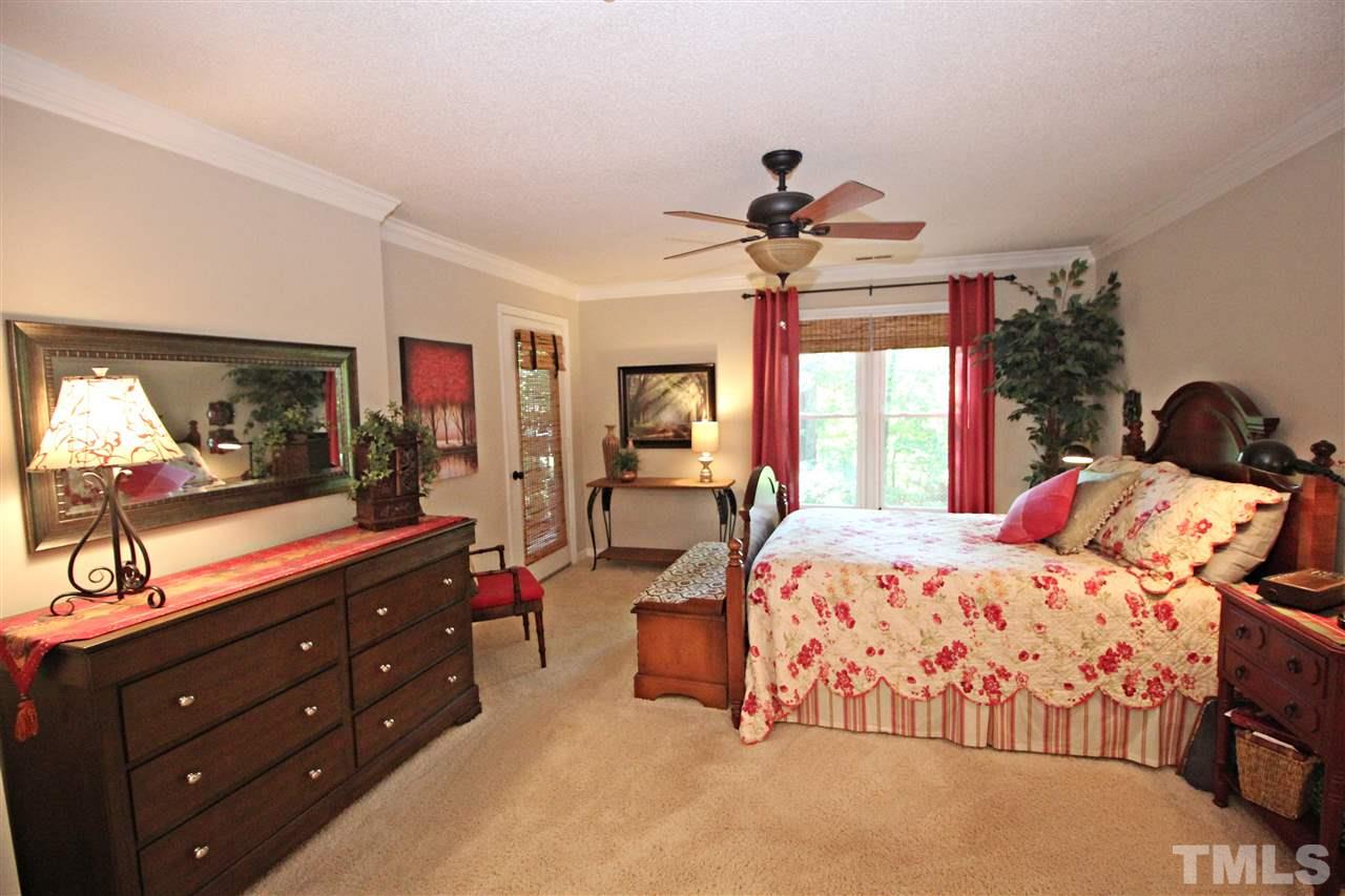 921 Springfork Drive Cary, NC 27513 - Photo 12 of 22 a bedroom with a bed and a large mirror on the dresser