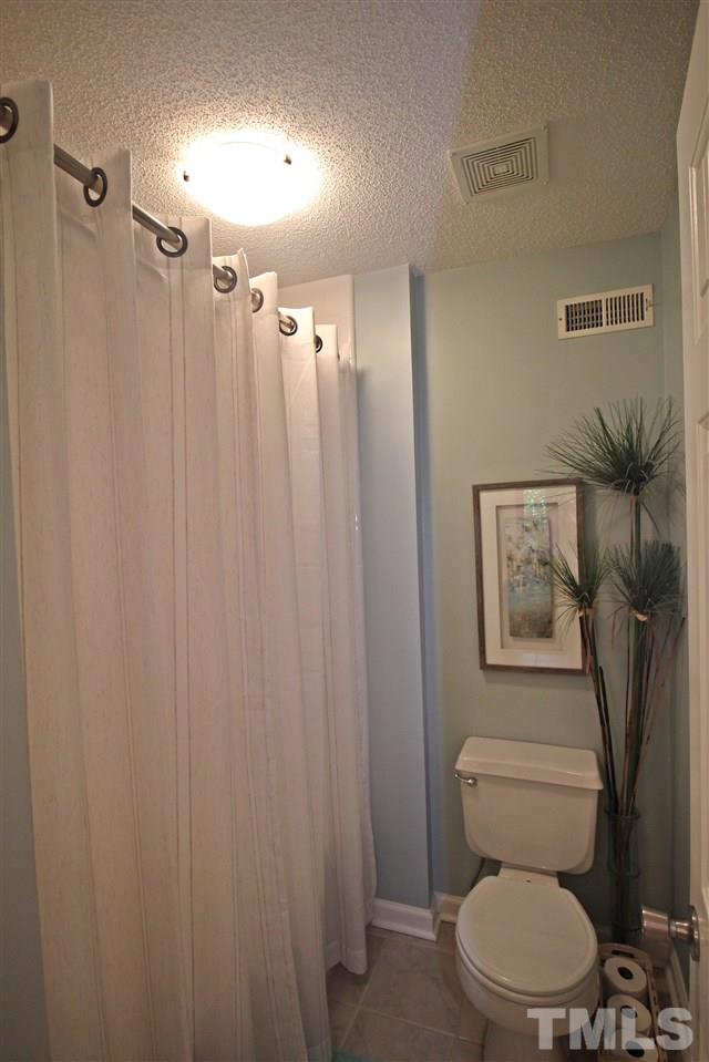 921 Springfork Drive Cary, NC 27513 - Photo 16 of 22 a white toilet sitting next to a bathroom sink and a shower