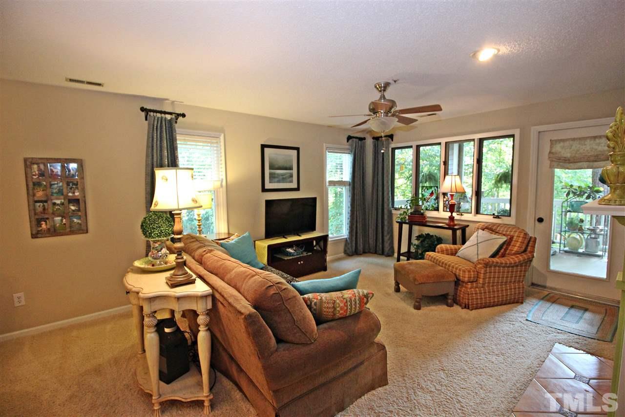 921 Springfork Drive Cary, NC 27513 - Photo 9 of 22 a living room with furniture a ceiling fan and a window