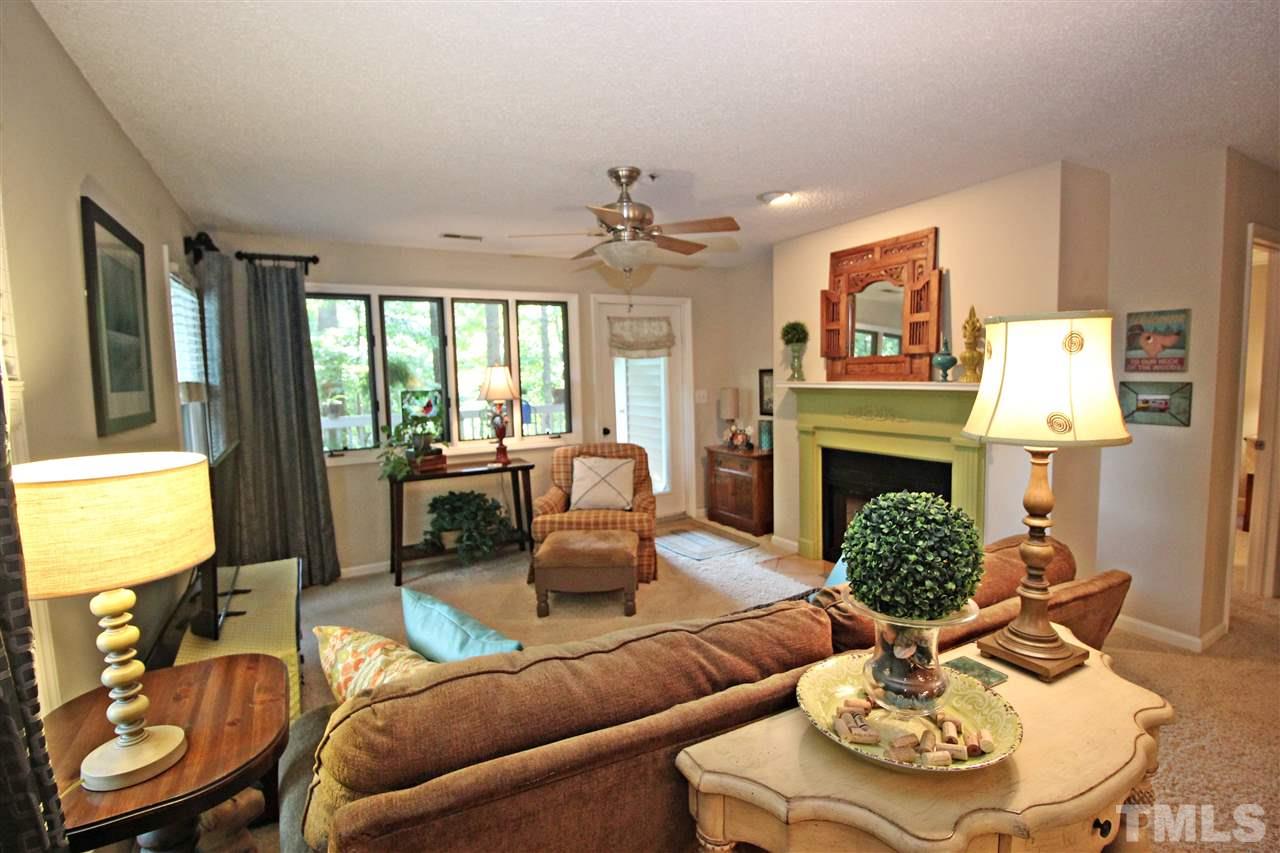 921 Springfork Drive Cary, NC 27513 - Photo 10 of 22 a living room with furniture a fireplace and a large window