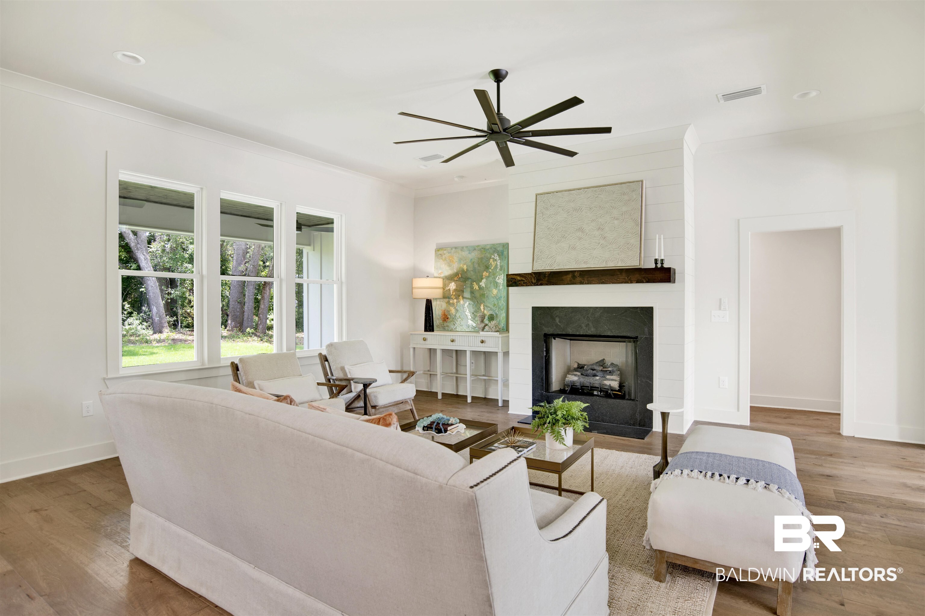 9275 Clarke Ridge Road Foley, AL 36535 - Photo 11 of 43 Living room featuring a ceiling fan, wood finished floors, ornamental molding, a large fireplace, and baseboards