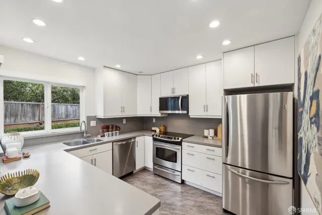 a kitchen with a refrigerator a sink and a stove top oven