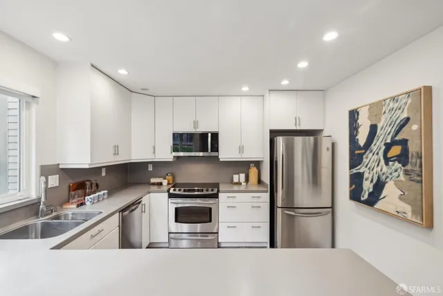 a kitchen with stainless steel appliances granite countertop a refrigerator stove and microwave