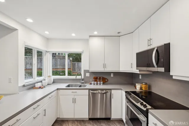 a kitchen with granite countertop a stove a sink and a microwave