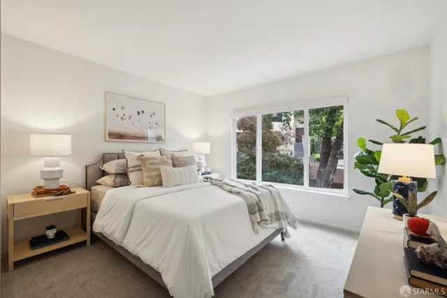 a bedroom with a bed and a large window