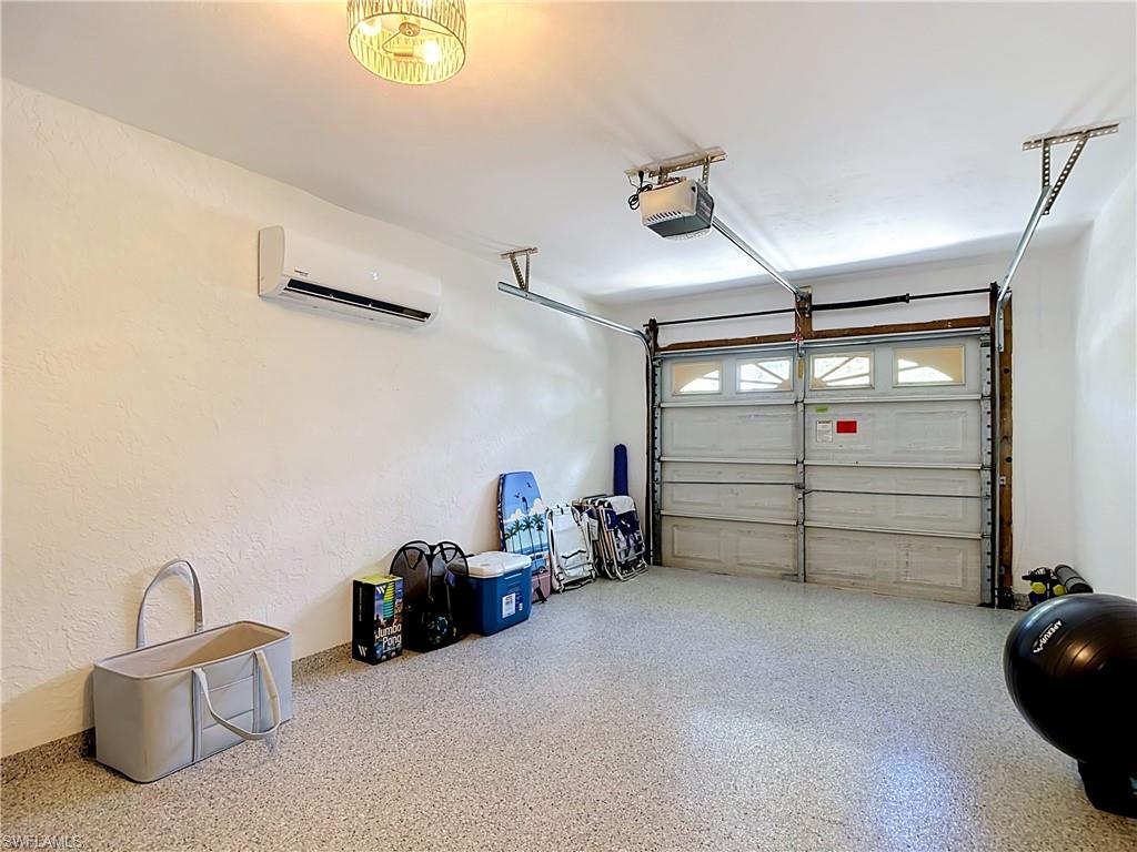 812 102nd Avenue North Naples, FL 34108 - Photo 33 of 33 Garage featuring a split air conditioning unit, light fixture, and a durable speckled epoxy floor coating