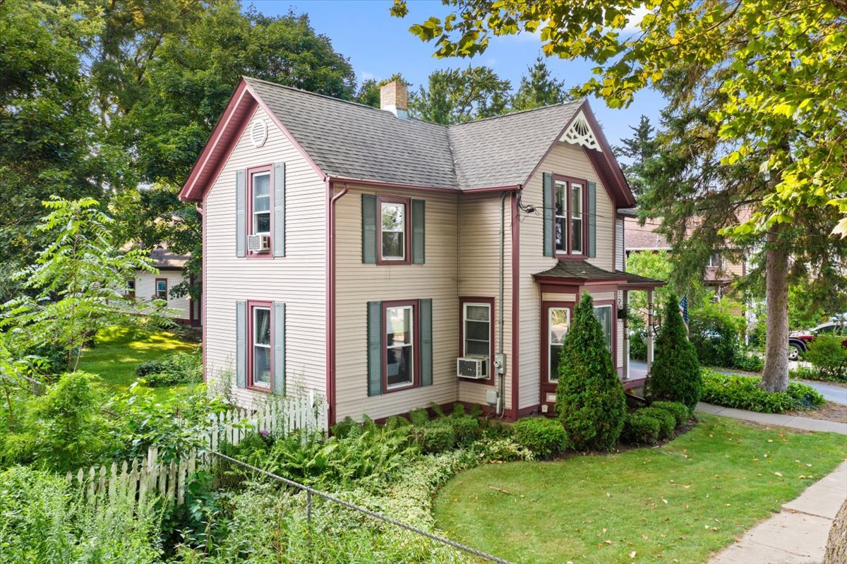 116 Spring Street Cary, IL 60013 - Photo 3 of 45 a view of a house with brick walls and a yard with plants
