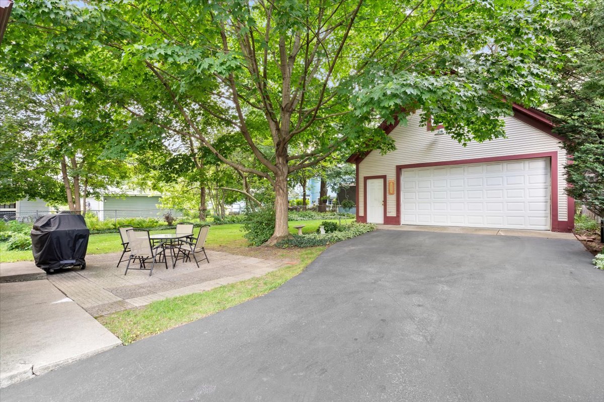 116 Spring Street Cary, IL 60013 - Photo 31 of 45 a view of a patio with table and chairs potted plants and large tree