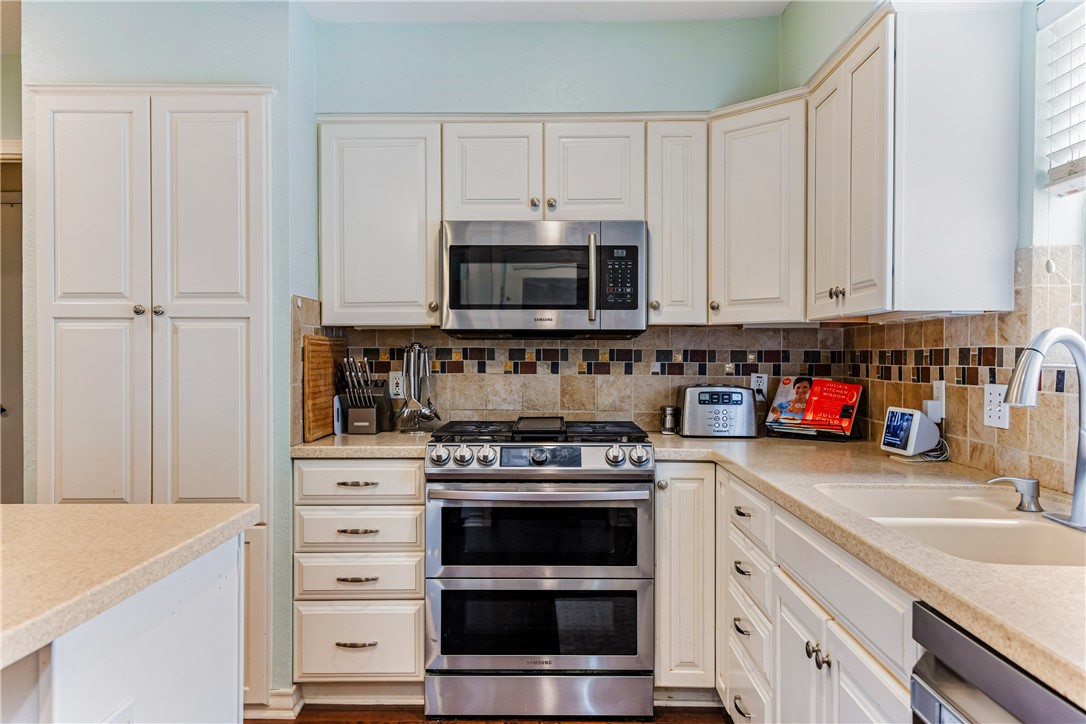 3350 Mavis Drive Corpus Christi, TX 78411 - Photo 11 of 40 a kitchen with granite countertop white cabinets and stainless steel appliances