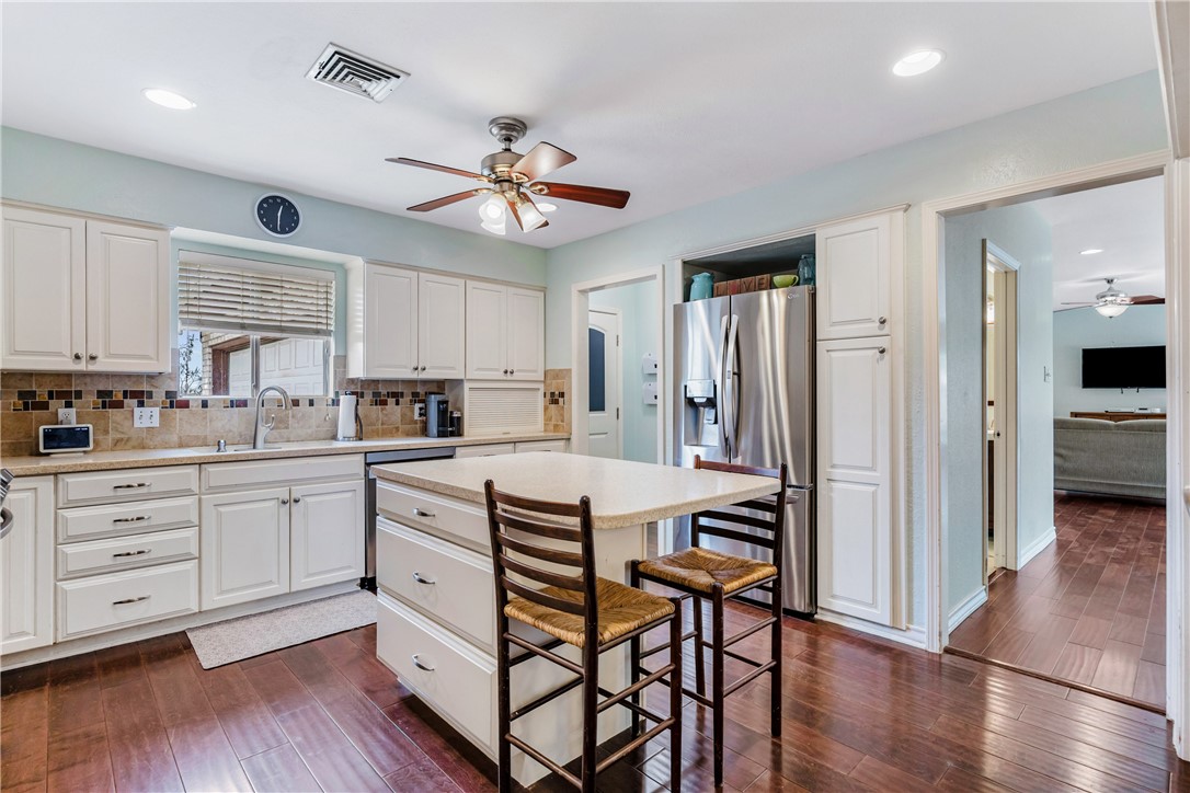 3350 Mavis Drive Corpus Christi, TX 78411 - Photo 9 of 40 a kitchen with stainless steel appliances white cabinets and wooden floor