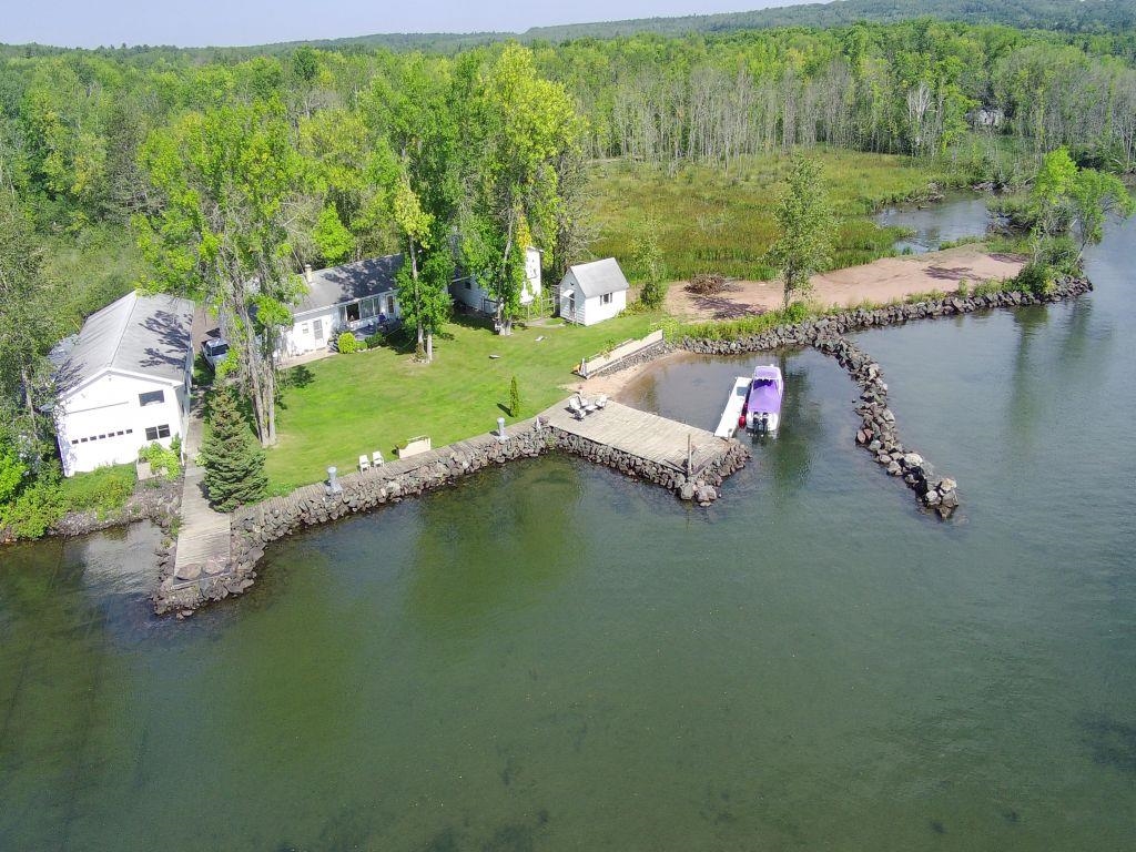 Aerial view of a nearby body of water and a heavily wooded area