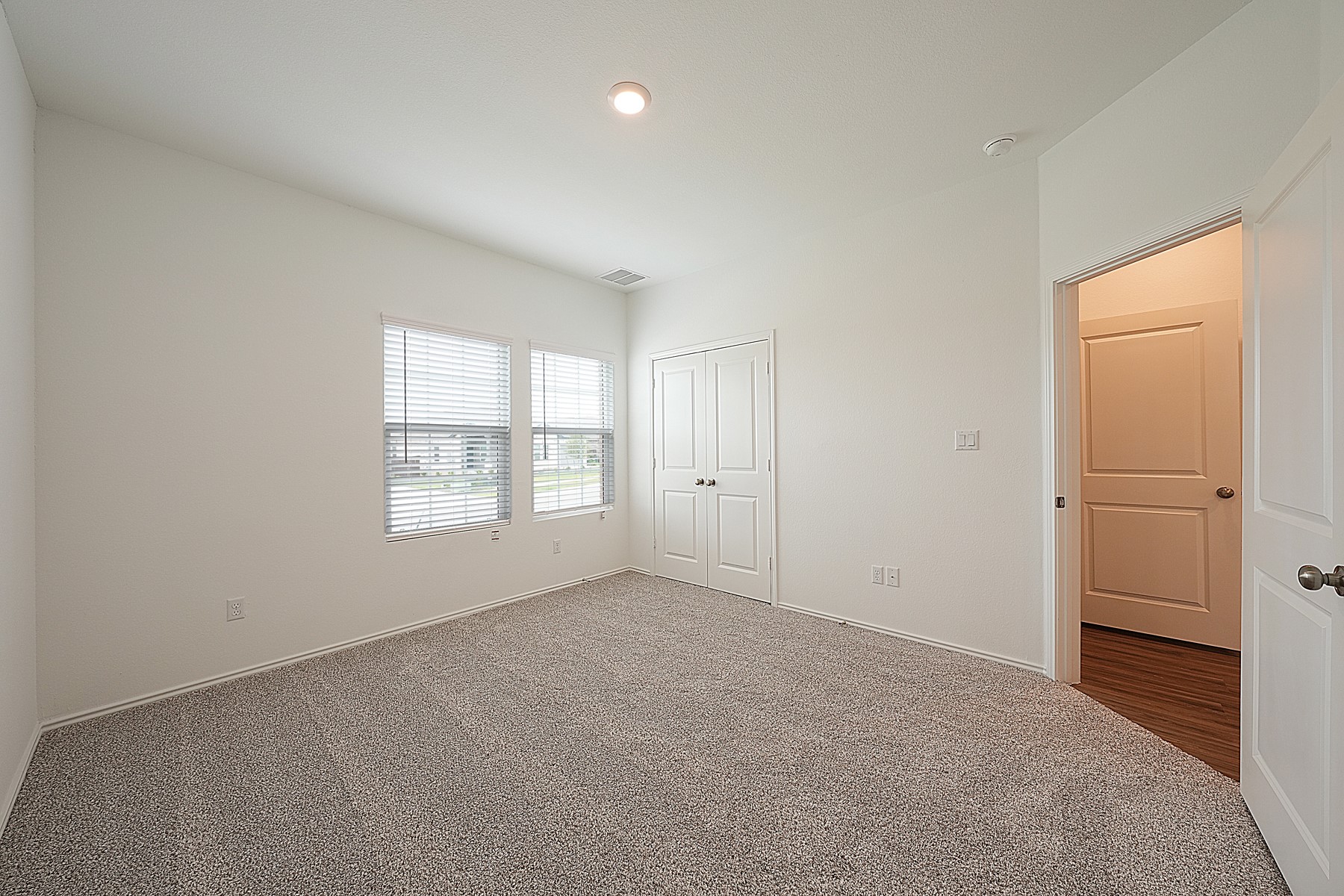 932 Mallow Road Leander, TX 78641 - Photo 10 of 34 A well-lit bedroom features plush carpeting and functional window blinds, offering a serene retreat.