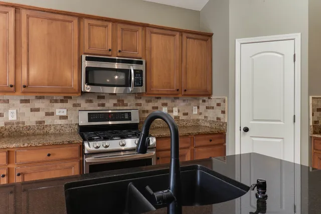 a kitchen with granite countertop a stove and a sink