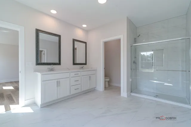 a spacious bathroom with double vanity and a mirror