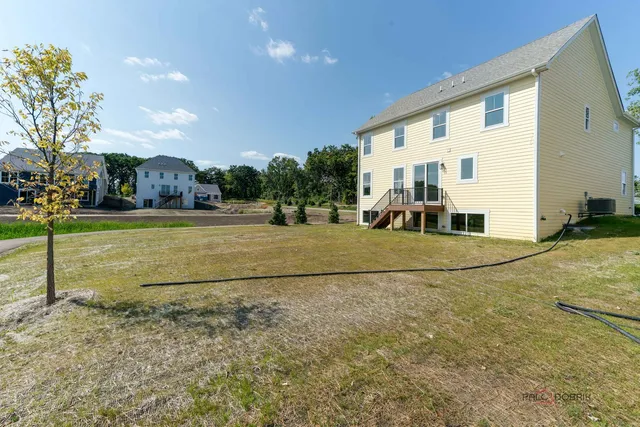 a view of a white house with a yard and table and chairs