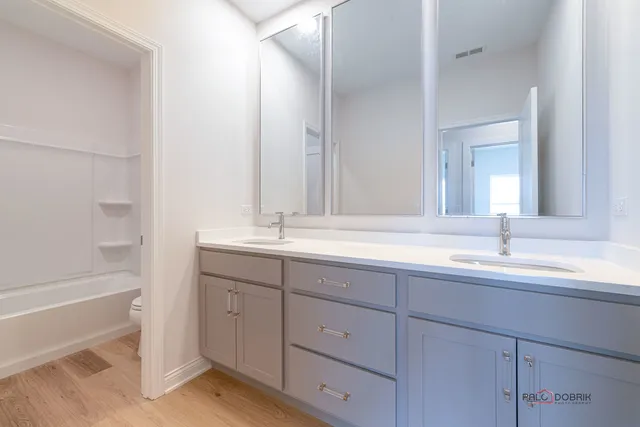 a bathroom with double sink and a mirror