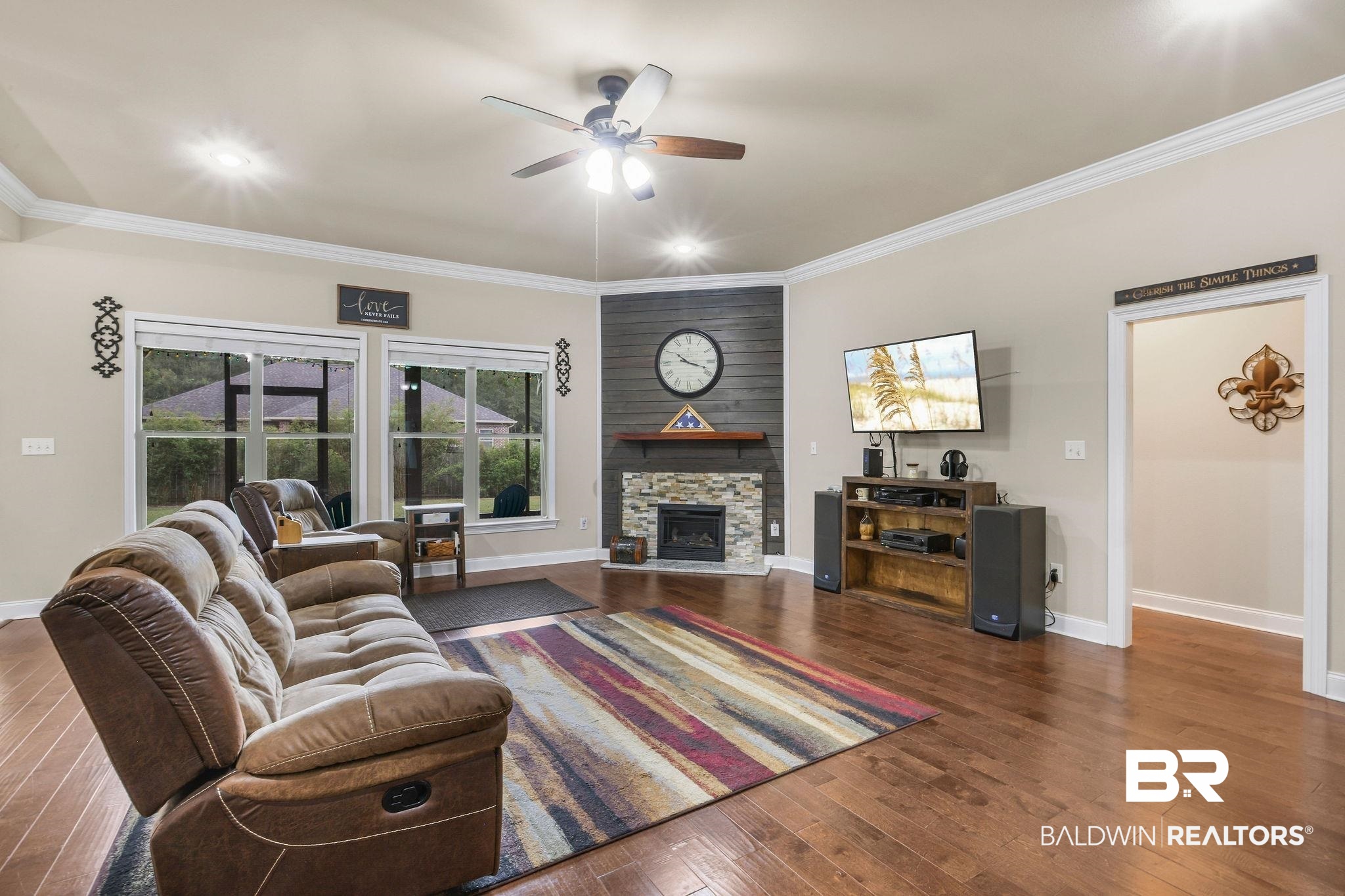 1086 Destin Avenue Foley, AL 36535 - Photo 6 of 30 Living room featuring ornamental molding, dark hardwood / wood-style floors, a stone fireplace, and ceiling fan