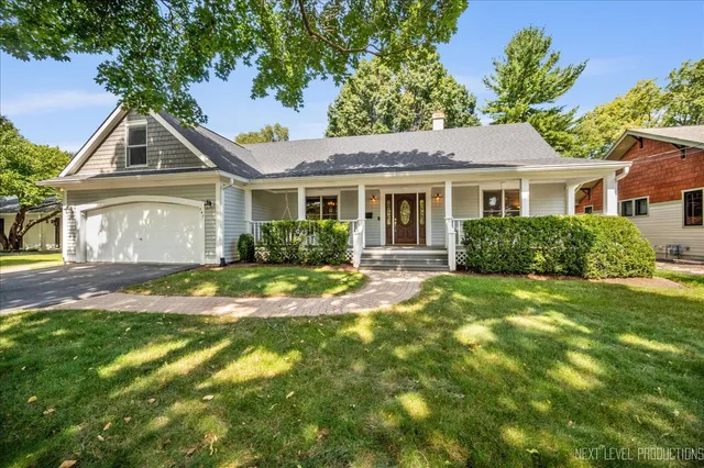 a front view of a house with a yard and potted plants