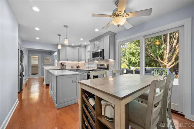 a open kitchen with a table chairs microwave and cabinets