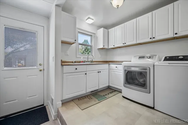 a utility room with cabinets washer and dryer