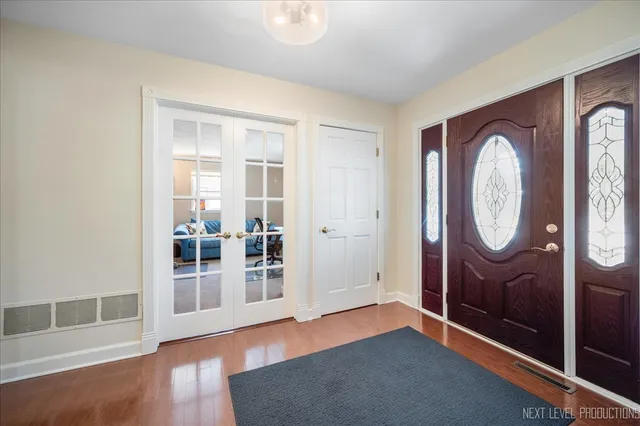 an empty room with wooden floor and entrance