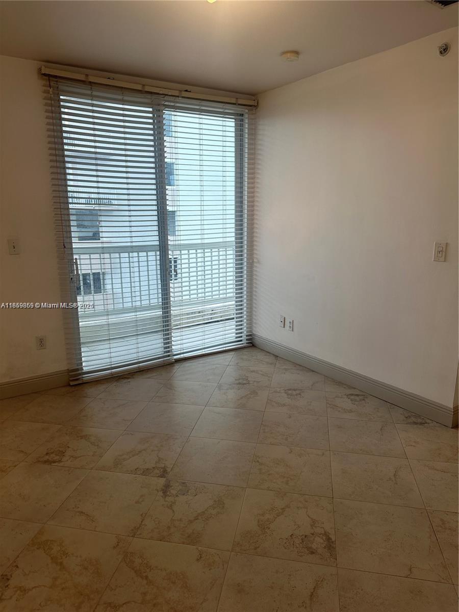 2400 Southwest 27th Avenue, Unit 406 Miami, FL 33145 - Photo 20 of 31 an empty room with wooden floor and windows