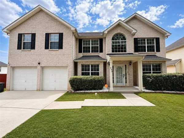 a front view of a house with a yard and garage