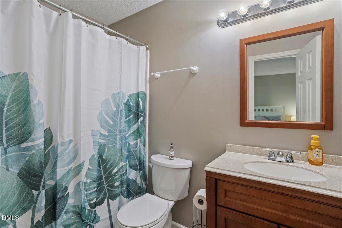 100 Hunting Chase, Unit 1D Cary, NC 27513 - Photo 18 of 29 a bathroom with a granite countertop sink and a toilet