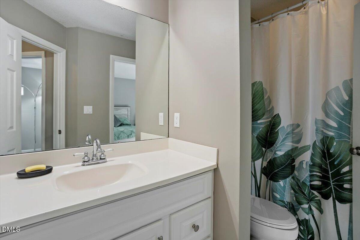 100 Hunting Chase, Unit 1D Cary, NC 27513 - Photo 25 of 29 a bathroom with a sink a toilet and a mirror