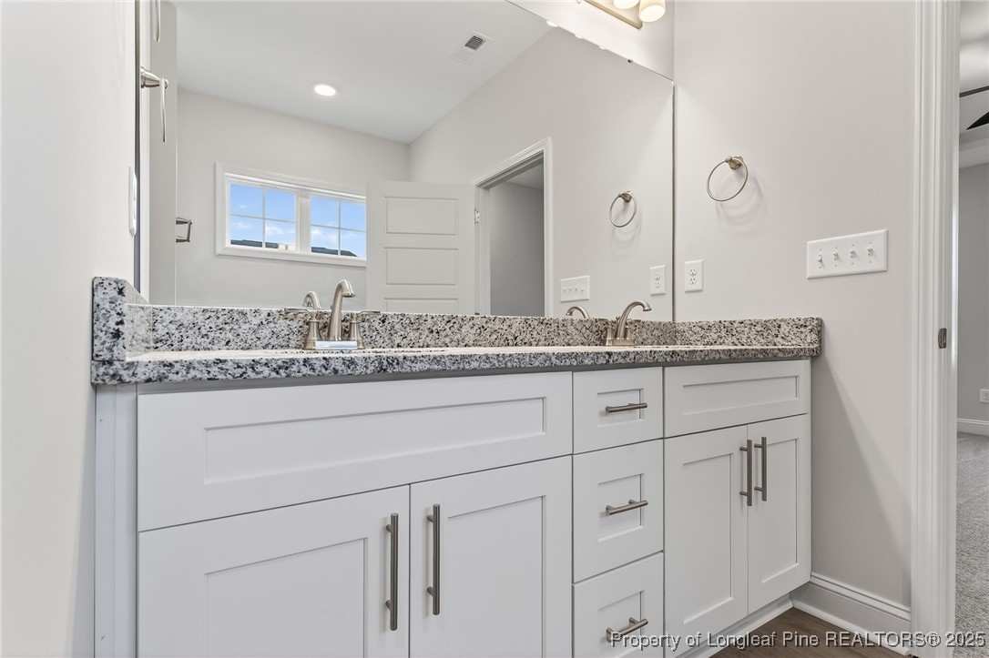 2202 Montrose (lot 3) Road Raeford, NC 28376 - Photo 32 of 44 a bathroom with a granite countertop sink and white cabinets