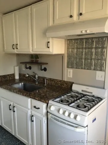 a white stove top oven sitting inside of a kitchen