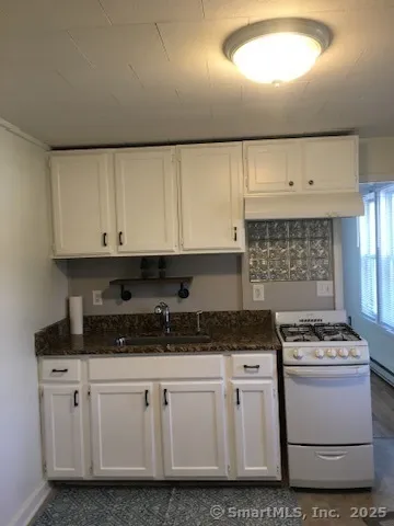 a kitchen with granite countertop white cabinets and white appliances