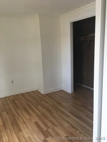 a view of an empty room with closet and a window