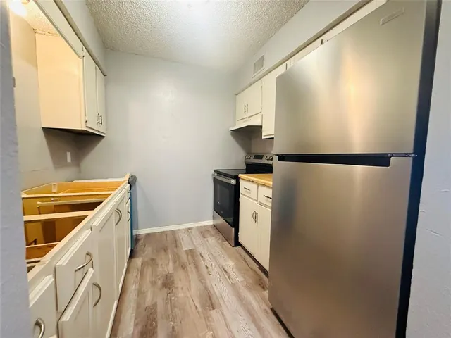 a kitchen with white cabinets and white appliances
