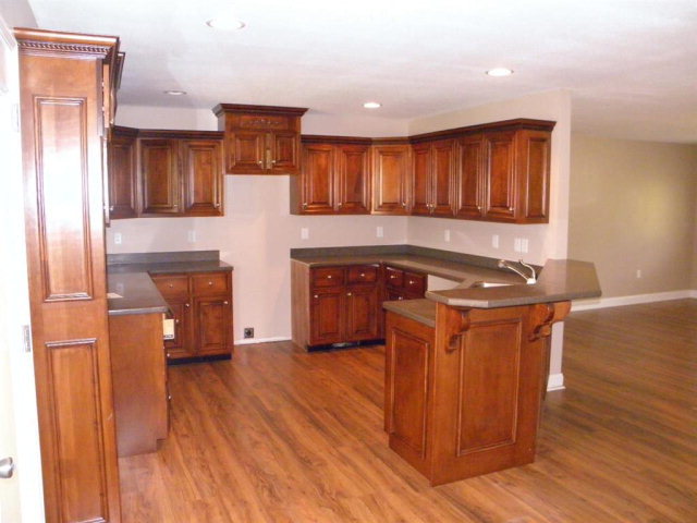 1218 Bowers Cemetery Road Cochran, GA 31014 - Photo 16 of 21 a kitchen with stainless steel appliances granite countertop a sink a stove a refrigerator and island with wooden floor